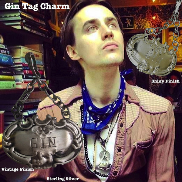 On Reeve Carney-Dorian Gray of Penny Dreadful and Rocky Horror's Riff Raff, Spider-Man on Broadway.Meant to adorn a neck of a different kind, this Gin Tag adapts beautifully, and why NOT? With its beautiful 2" of on of my most favorite chains attached to the perfect bail, which opens and snaps over beads or pearls easily or slips through the most rugged chain. Engraved and ornate and available in either shiny or my vintage oxidized finish. Even teetotalers like this!  (Chains sold separately.)  1-3/4" x 1" 