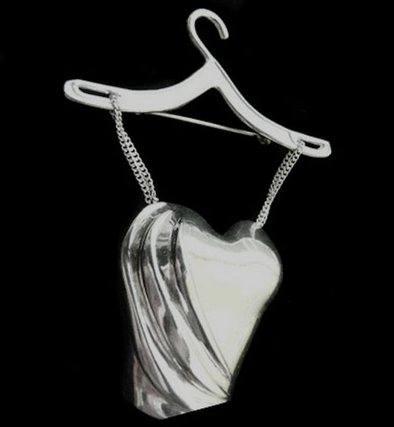 This pin was inspired by my love of Barbie dolls as a child...and my love of lingerie as an adult... (and the fact that I was at one time a top lingerie model in NYC) it is at once, innocent and sensuous. And for you Showtime Penny Dreadful fans, it is reminiscent of one of Vanessa Ives' corsets! Sterling Silver. Suspended by delicate silver chains, this bustier/corset hangs from a sterling silver clothing hanger. (Hanger also available as a single charm).