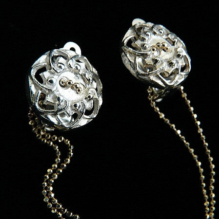 Delicate and hanging by a thread, this beautiful Sterling Silver flowered button has a 4" piece of chain threaded through its double holes, like the fluttering...