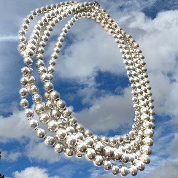 here is a reason these "pearls" are a Fables "Classic". Whether you like Jackie Kennedy or Prince, you should own this extra-long Sterling Silver Pearl necklace with its heart clasp. If you can only take one accessory on any trip, let it be this versatile strand of Silver Pearls.(It is also a perfect gift for a bride!) A generous 5 feet of 7mm Sterling Silver Pearls with a heart clasp. Hand made in the USA. Hand Signed.
