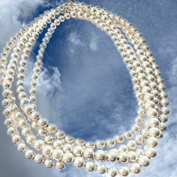 here is a reason these "pearls" are a Fables "Classic". Whether you like Jackie Kennedy or Prince, you should own this extra-long Sterling Silver Pearl necklace with its heart clasp. If you can only take one accessory on any trip, let it be this versatile strand of Silver Pearls.(It is also a perfect gift for a bride!) A generous 5 feet of 7mm Sterling Silver Pearls with a heart clasp. Hand made in the USA. Hand Signed.