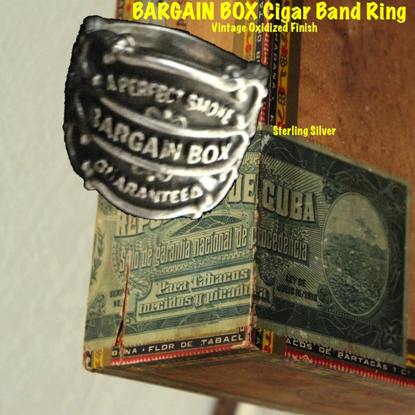 Vintage antique cuban cigar bands come to life as Sterling Silver Cigar Band Rings in 3D fashion statements. Shown here on an antique Cuban cigar box. Ready for any cigar aficionado or collector.