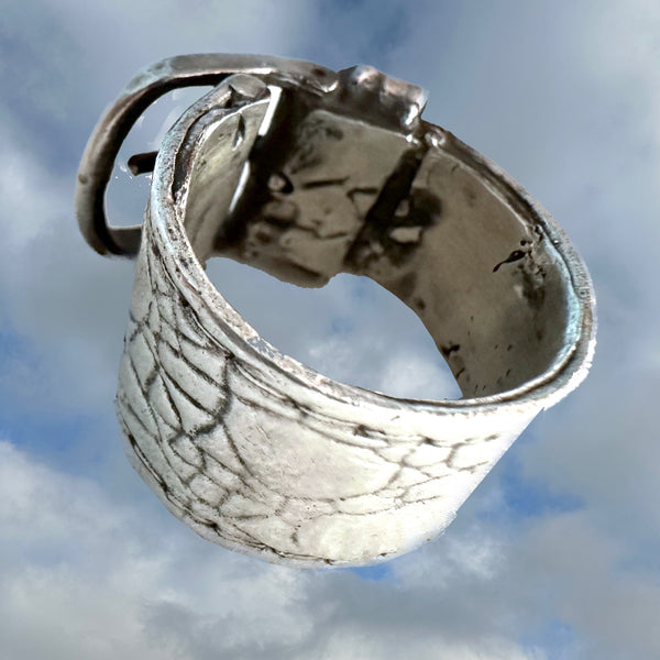 Substantial piece of pure vintage rock and roll--as seen on Zane Carney, in Avril Lavigne's "I Fell in Love with the Devil"Music Video.. Opulent,finely detailed band of timeless whimsy in Oxidized Sterling Silver Buckle Ring makes a statement alone or as part of a collection of fables...Sterling Silver distressed Crocodile textured buckle ring. Handmade in America and Hand-signed.