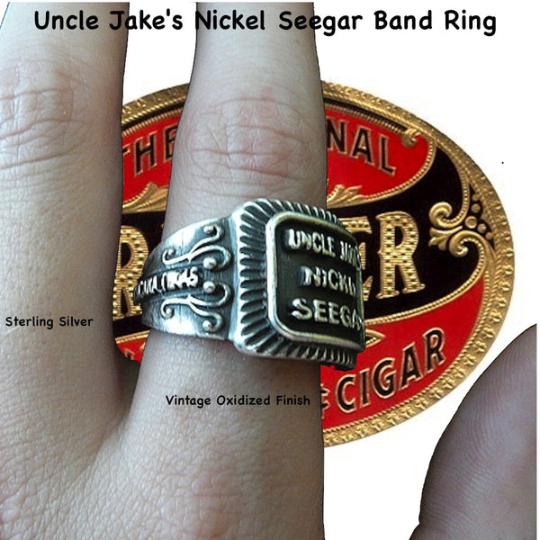 Even if you are not a cigar aficionado, this vintage cigar band ring is "smoking". The first in what will be an expansive and whimsical collection,  this 3D version of an actual antique "Seegar" band--the first of its kind. Sterling Silver in my antique satin oxidized finish to bring the old cigar band to life once again!  Top 1/2" wide approximately.  Made in the USA by hand. Hand signed.  Sterling Silver Uncle Jake's Nickel Seegar Cigar Band Ring.  Be sure to check out my other two cigar band rings--Mild 